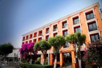 Un edificio naranja con árboles delante. en Hotel Emily, en Pachuca de Soto