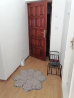 a room with a door and a rug and a chair at Flowers Apartment Tuzla in Tuzla