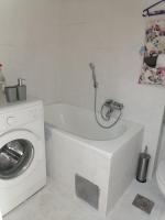 a bathroom with a washing machine and a washer at Flowers Apartment Tuzla in Tuzla