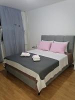 a bed with two towels on top of it at Flowers Apartment Tuzla in Tuzla