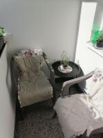 a living room with a chair and a table at Flowers Apartment Tuzla in Tuzla