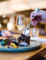 a person eating a piece of cake with a fork at Louis Hotel in Munich