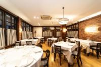 ein Restaurant mit weißen Tischen und Stühlen und einer Backsteinwand in der Unterkunft Hotel Restaurante De Torres in Felechosa