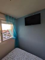 a bedroom with a bed and a television on the wall at Charmant appartement à Sainte Marie la mer (66470) in Sainte-Marie-Plage