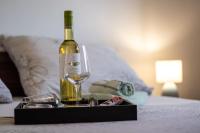 a bottle of wine and a glass on a bed at Lucija in Lovinac