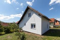 a small white house with a triangular roof at Lucija in Lovinac