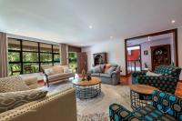 a living room with couches and chairs and a table at Deerpark Luxury Stays in Nairobi