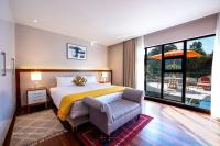 a bedroom with a bed and a chair and a window at Deerpark Luxury Stays in Nairobi