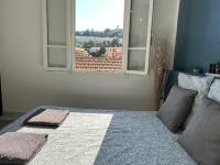 a bedroom with a bed and a window with a view at La maison de Giulia Menton in Menton