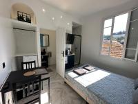a bedroom with a bed and a desk and window at La maison de Giulia Menton in Menton