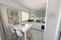 a white kitchen with a white table and chairs at Studio with balcony - 2 min beach and AquaBaule in La Baule
