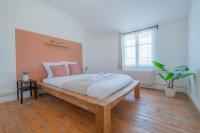 a bedroom with a large wooden bed with pink pillows at Spacy Rock in Reims