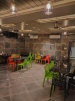 Un comedor con mesas y sillas en un restaurante. en Hotel Garuda Executive Latur, en Lātūr