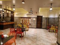 Un restaurante con mesas y sillas y un bar. en Hotel Garuda Executive Latur, en Lātūr