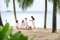 a family sitting on the beach at Vinpearl Resort & Spa Phu Quoc in Phú Quốc