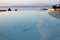 a swimming pool with a view of the water at Hôtel Royal in Évian-les-Bains
