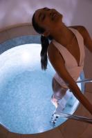 a woman in a pink dress standing next to a swimming pool at Hôtel Royal in Évian-les-Bains