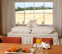 a bed with two stuffed animals on it in front of a window at Tertin Kartano in Mikkeli