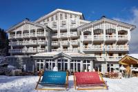 a hotel in the snow with two chairs in front of it at Ecrin Blanc Resort Courchevel in Courchevel