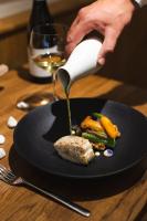 リガにあるDome Hotelの食皿にソースを注いでいる人