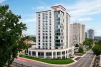 ハミルトンにあるHampton Inn By Hilton Hamiltonの上に看板がある背の高い白い建物