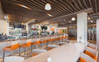 a bar with white tables and orange chairs at Living Water Resort & Spa in Collingwood