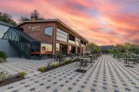 un edificio con mesas y sillas en un patio en Aronia Bungalow, en Elmalık
