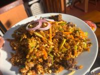 um prato de alimentos com arroz e legumes sobre uma mesa em Thisha Hotel & Restaurant em Jaffna