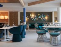 a restaurant with blue chairs and tables in a room at Hilton Garden Inn Marseille Provence Airport in Marignane