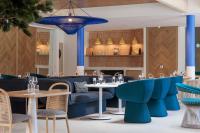 a restaurant with blue chairs and tables at Hilton Garden Inn Marseille Provence Airport in Marignane