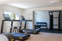 a gym with three treadmills and a treadmill at Hilton Garden Inn Marseille Provence Airport in Marignane