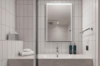 a white bathroom with a sink and a mirror at Hilton Garden Inn Marseille Provence Airport in Marignane