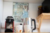 two coffee cups sitting on a counter next to a coffee maker at Les Hirondelles By Nid&#39;Ouest in Quimper