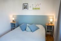 a bedroom with a white bed with blue pillows at Les Hirondelles By Nid&#39;Ouest in Quimper