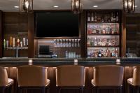 a bar with leather chairs and a flat screen tv at Delta Hotels by Marriott Ashland Downtown in Ashland