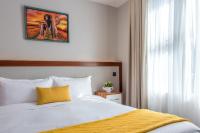 a bedroom with a bed with a yellow pillow at Deerpark Luxury Stays in Nairobi