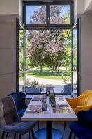 Una mesa y sillas en una habitación con una ventana grande. en Hôtel Au Château, en Villers-lès-Nancy