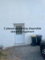 a white building with a door and two trash cans at Chez Leon et Louise in Saint-Gaudens
