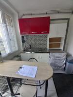 cocina con mesa de madera y armarios rojos en Fleurs de loutus 2, en Romilly-sur-Seine