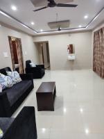 a living room with black couches and a coffee table at Rahul guest house and service apartment in Visakhapatnam