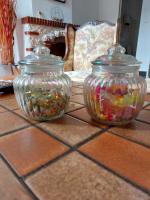 two glass jars filled with beads on a table at La Quiétude in Cotignac