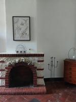 a living room with a brick fireplace with a picture on the wall at La Quiétude in Cotignac