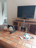 a living room with a television and a tiled floor at La Quiétude in Cotignac