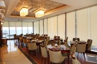 una sala da pranzo con tavoli, sedie e finestre di Tilya Resort Hotel a Trabzon