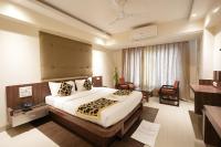una habitación de hotel con una cama y un escritorio en Hotel City Symphony, en Nanded