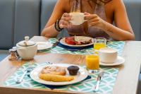 a woman sitting at a table with a plate of food at Leman Hotel y Apartamentos in Playa de Palma