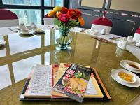 eine Zeitschrift auf einem Tisch mit einer Blumenvase in der Unterkunft Column Bangkok Hotel in Bangkok