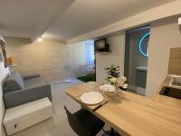 a living room with a table and a couch at Cosy Green - WIFI HD - NETFLIX GRATUIT in Avignon