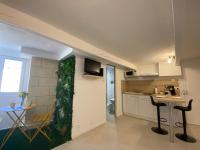a kitchen and a living room with a table and chairs at Cosy Green - WIFI HD - NETFLIX GRATUIT in Avignon
