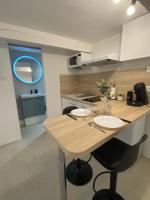 a kitchen with a counter with two chairs and a table at Cosy Green - WIFI HD - NETFLIX GRATUIT in Avignon